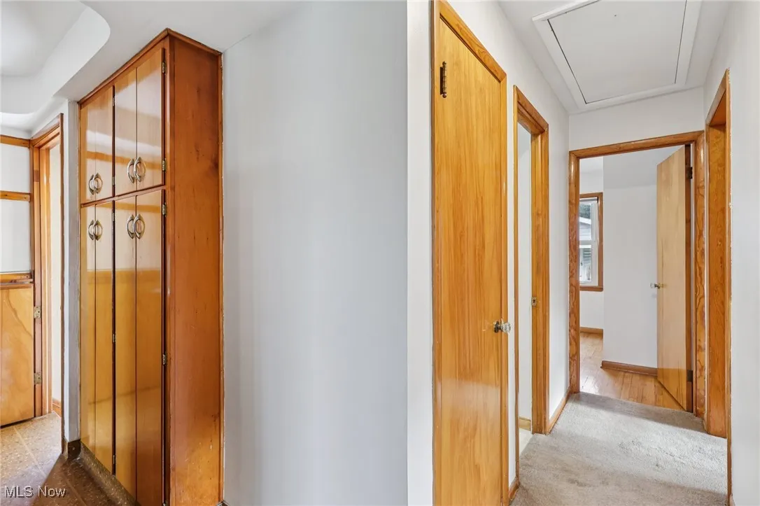 Corridor with light carpet and attic access
