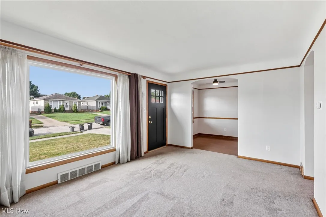 Foyer with light colored carpet and a residential view