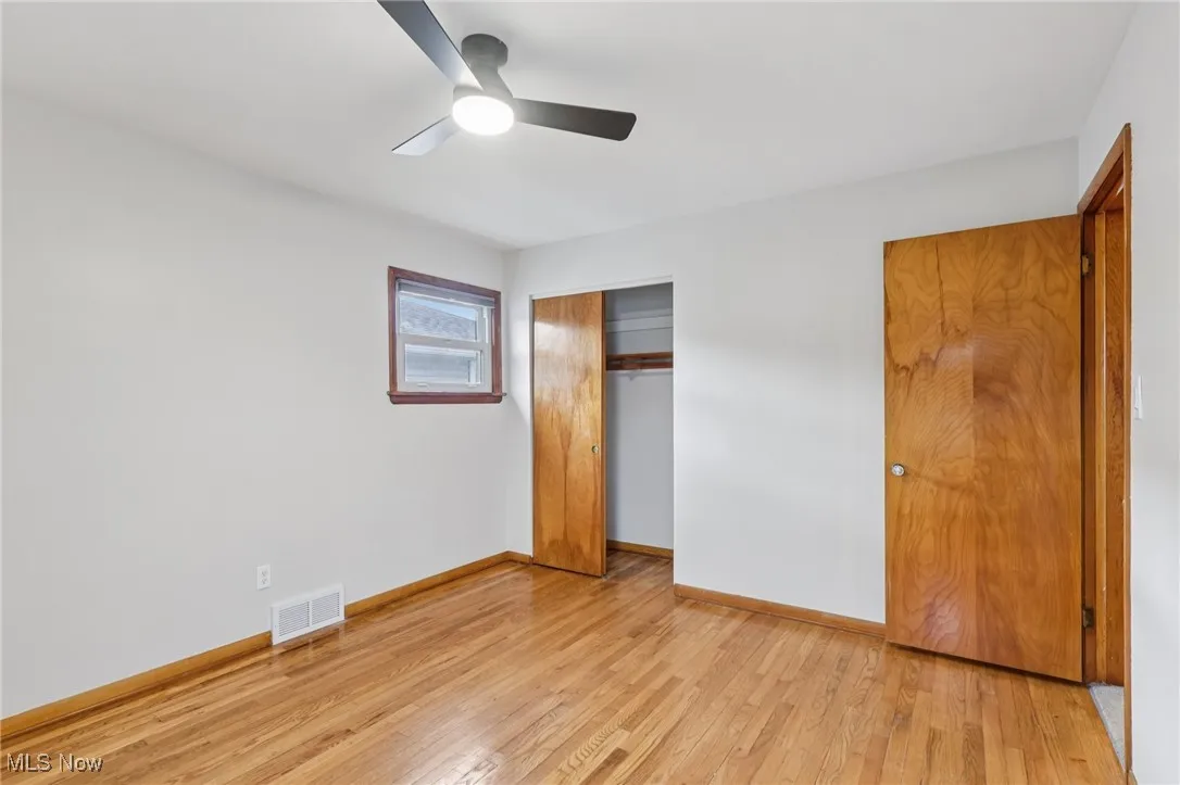Unfurnished bedroom with light wood-style flooring, ceiling fan, and a closet