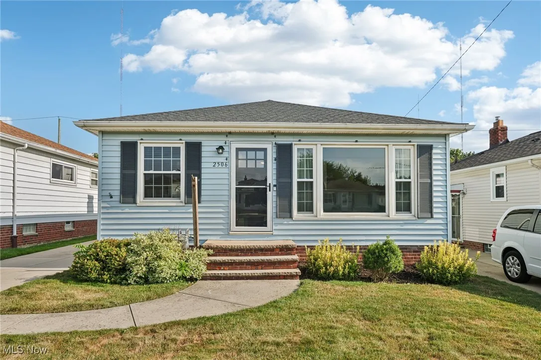Bungalow-style home with a front yard and a shingled roof