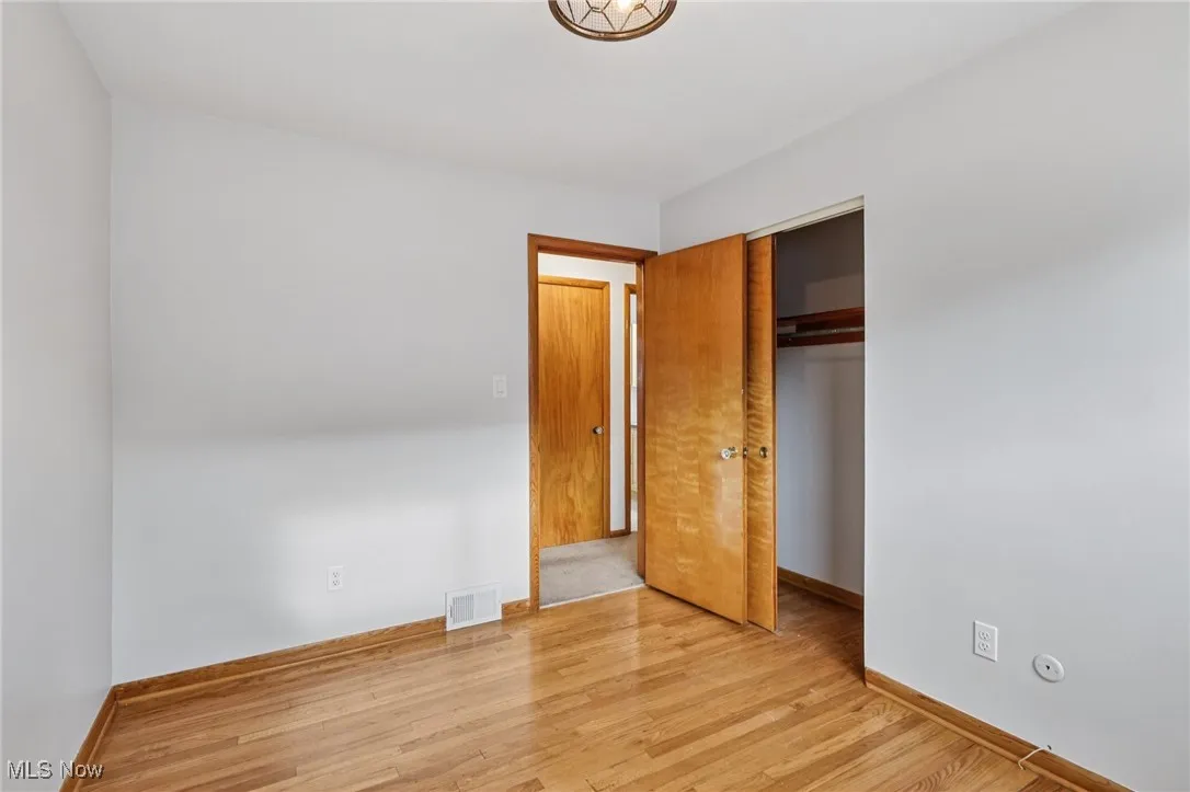 Unfurnished bedroom with light wood-style flooring and a closet