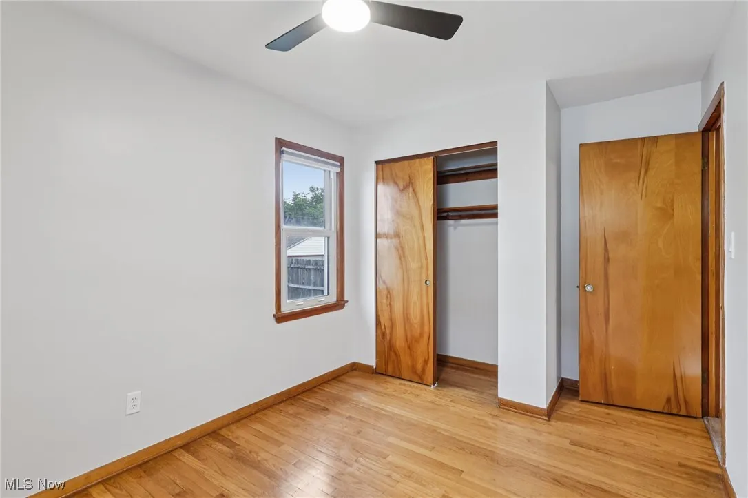Unfurnished bedroom featuring a closet, light wood-style flooring, and ceiling fan