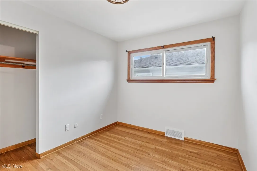 Unfurnished bedroom with light wood-style floors and a closet