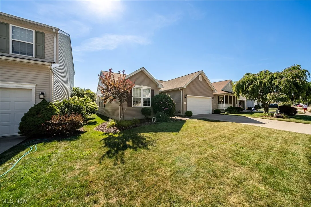View of front facade featuring driveway, a front yard, and a garage