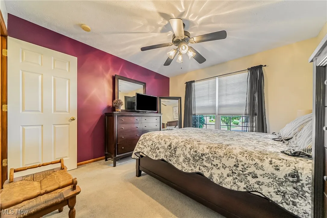 Bedroom featuring light carpet and a ceiling fan