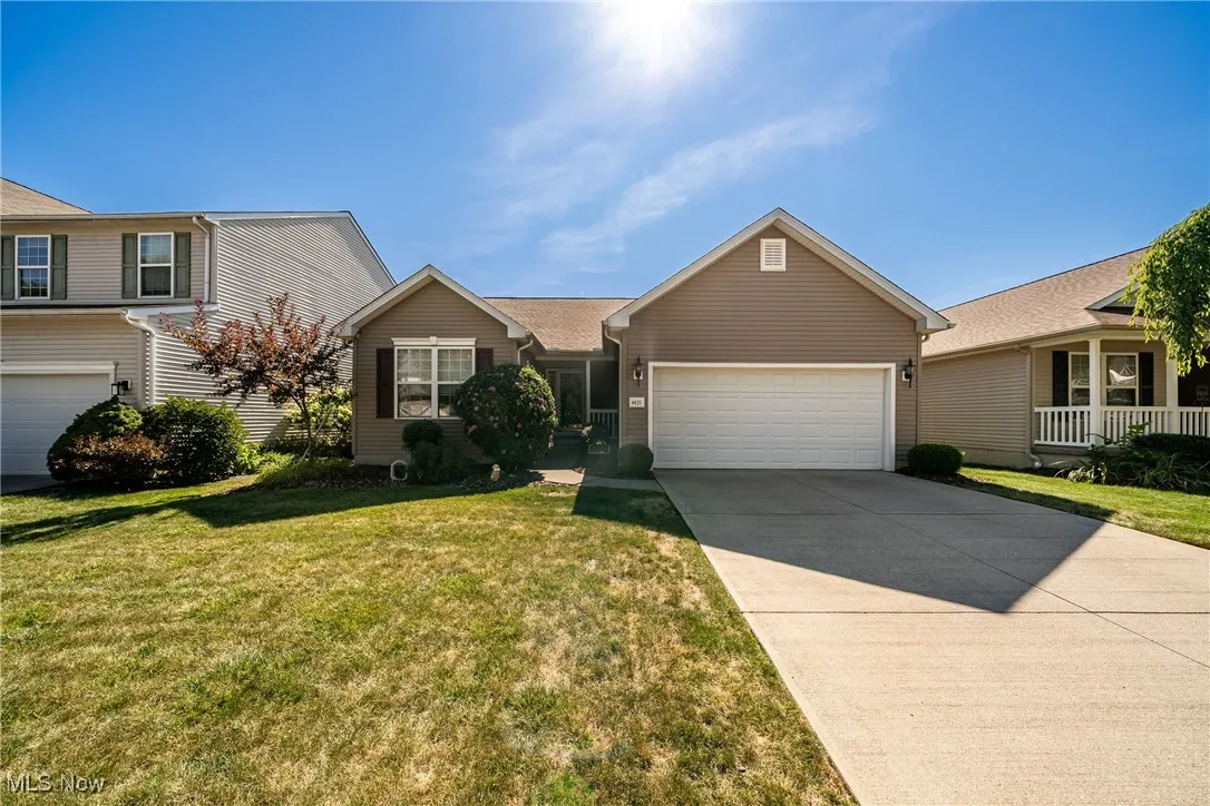 View of front facade featuring driveway, an attached garage, and a front yard