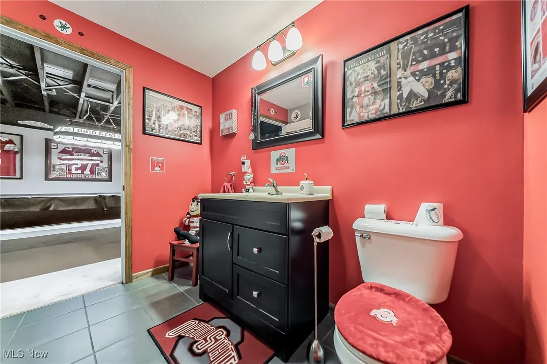 Half bath featuring vanity and dark tile patterned flooring