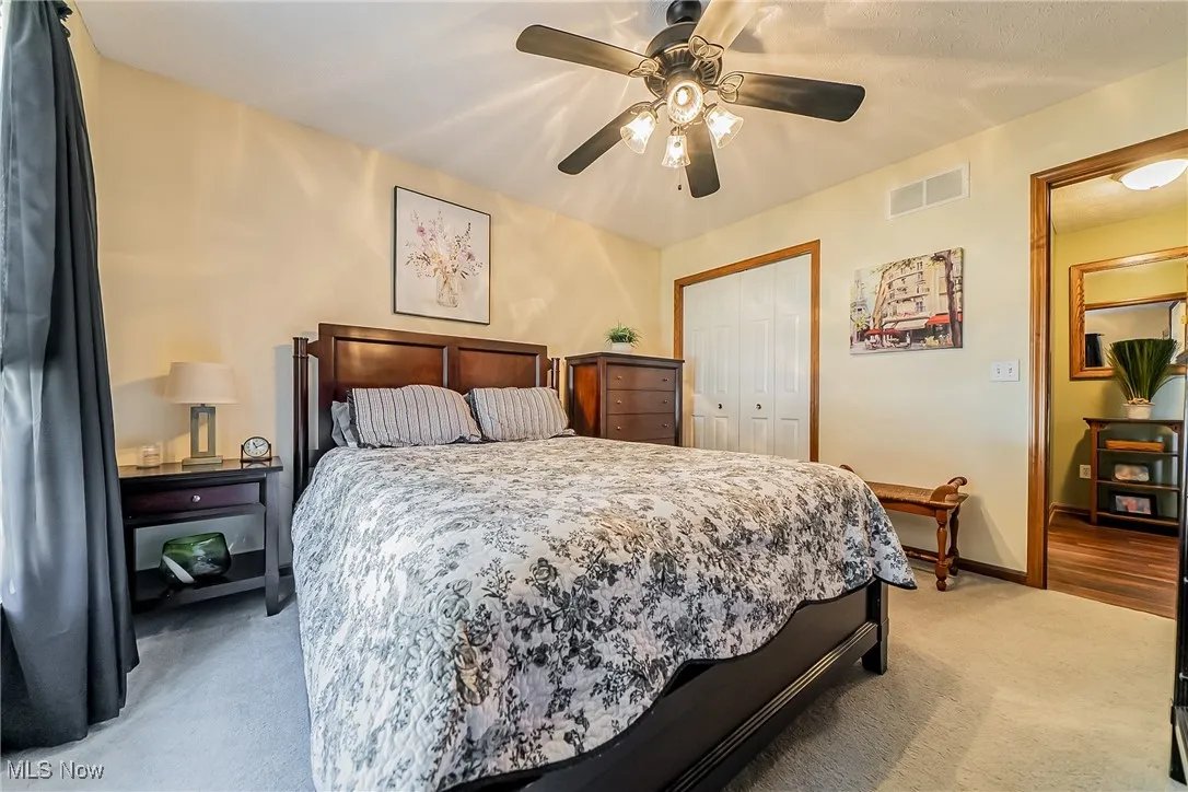 Bedroom featuring light carpet, a closet, and ceiling fan