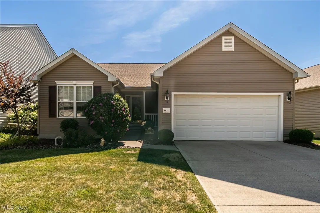 View of front of home featuring a garage, driveway, and a front yard