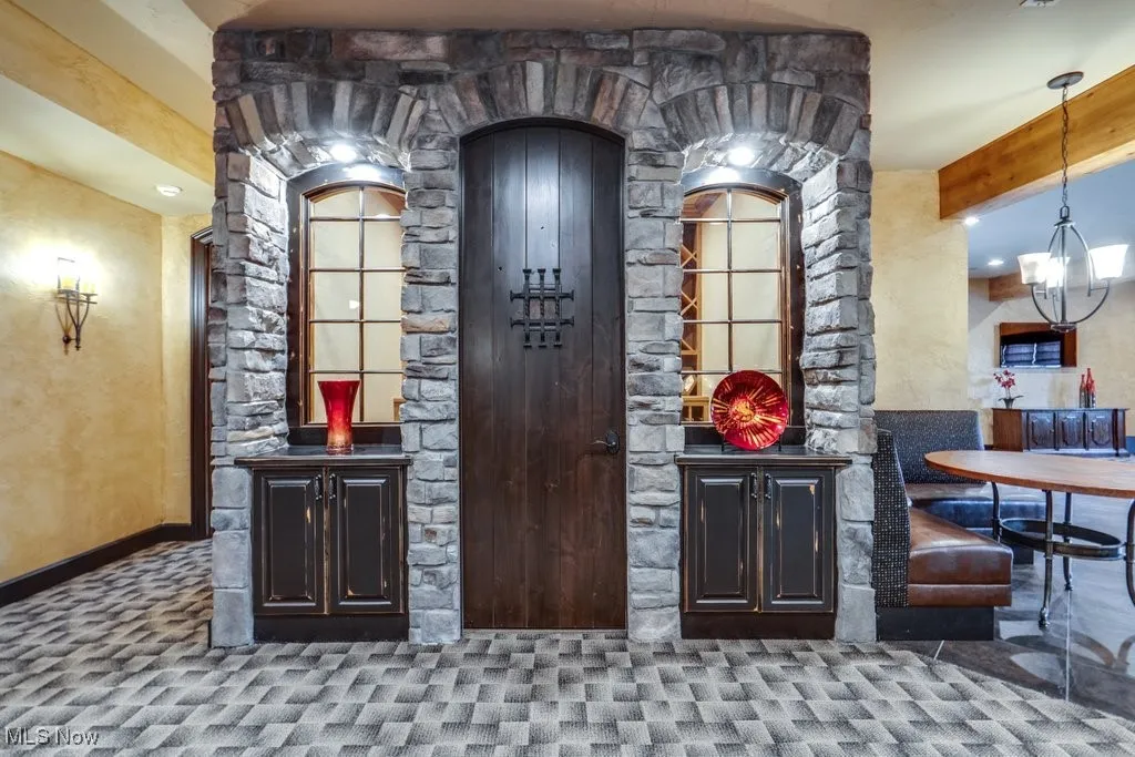 Bar with carpet, beam ceiling, and a chandelier