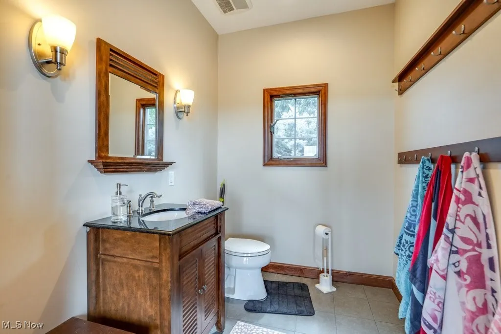 Half bathroom with vanity and light tile patterned floors