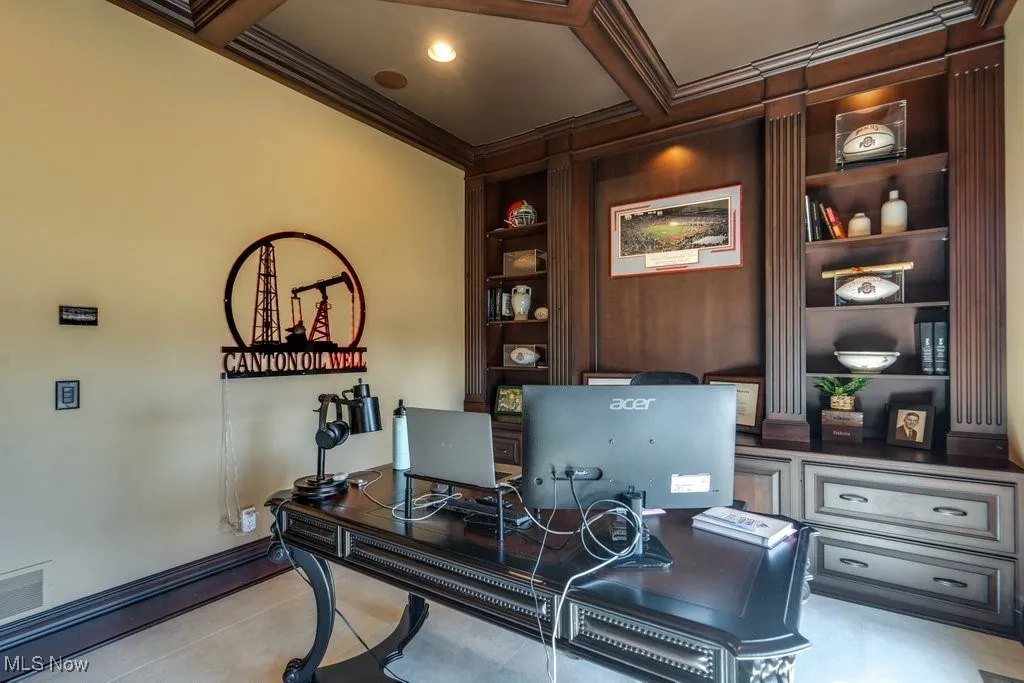 Home office with crown molding, beam ceiling, coffered ceiling, and built in features