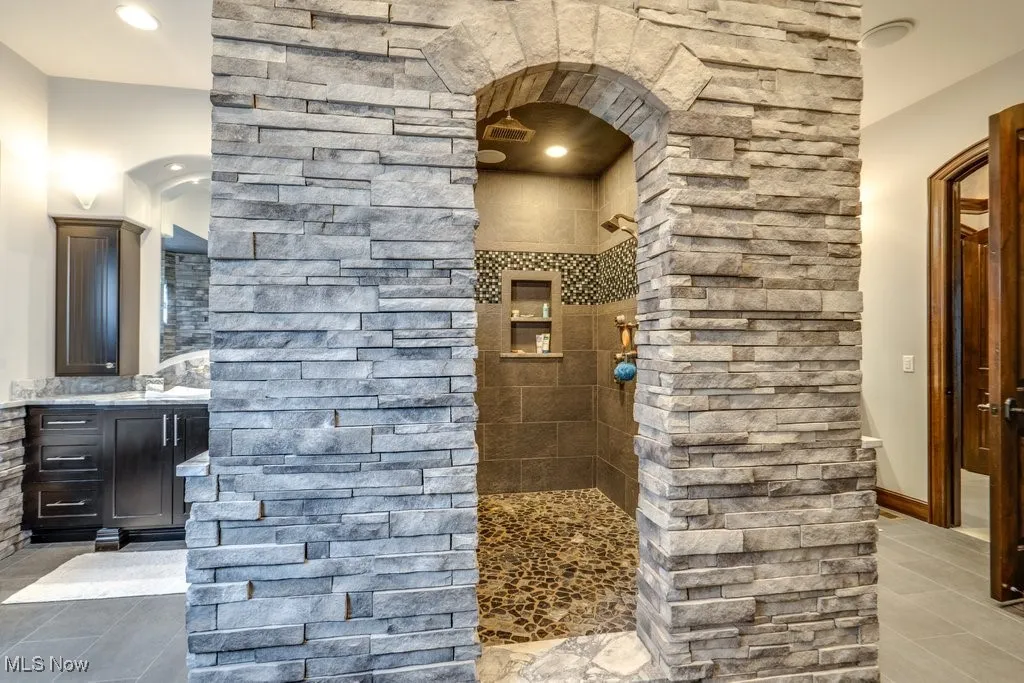 Full bathroom featuring a walk in shower, vanity, light tile patterned flooring, and recessed lighting