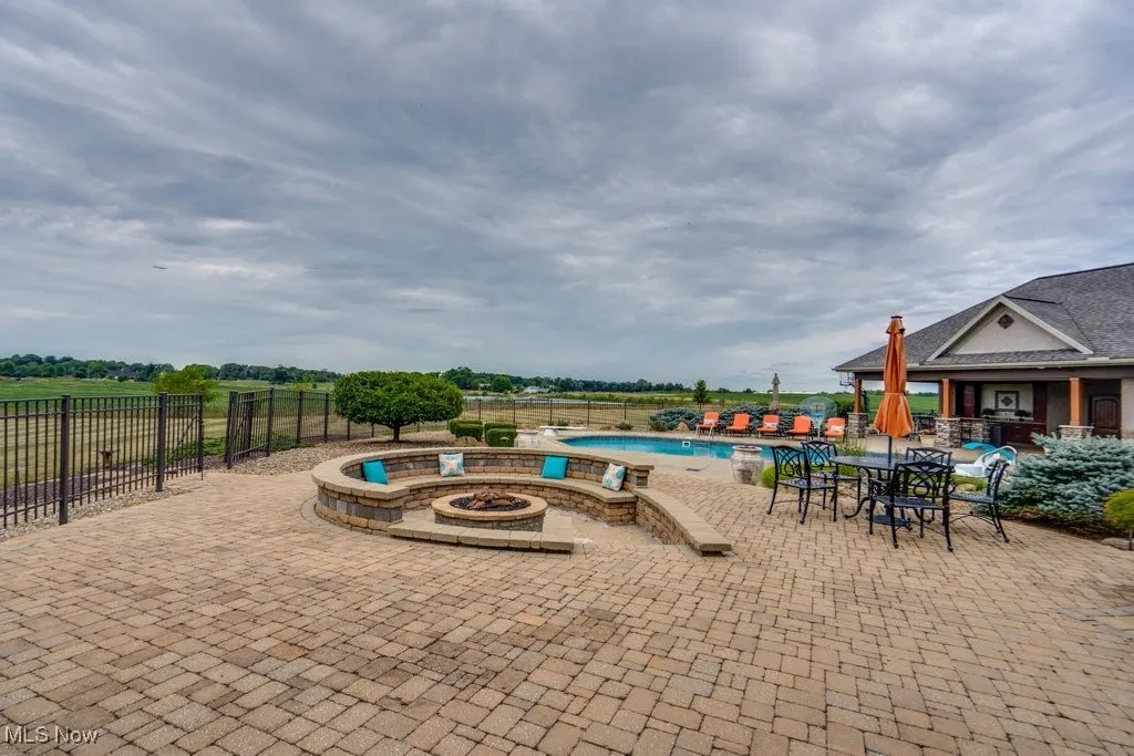 Community pool with a patio area and an outdoor fire pit
