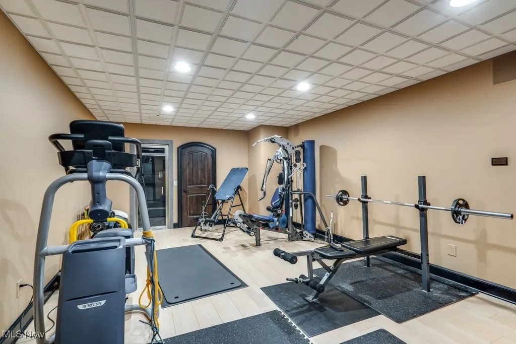 Workout room with wood finished floors and recessed lighting