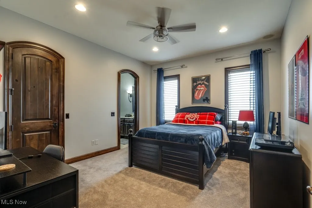 Bedroom with light colored carpet, ceiling fan, recessed lighting, a desk, and connected bathroom