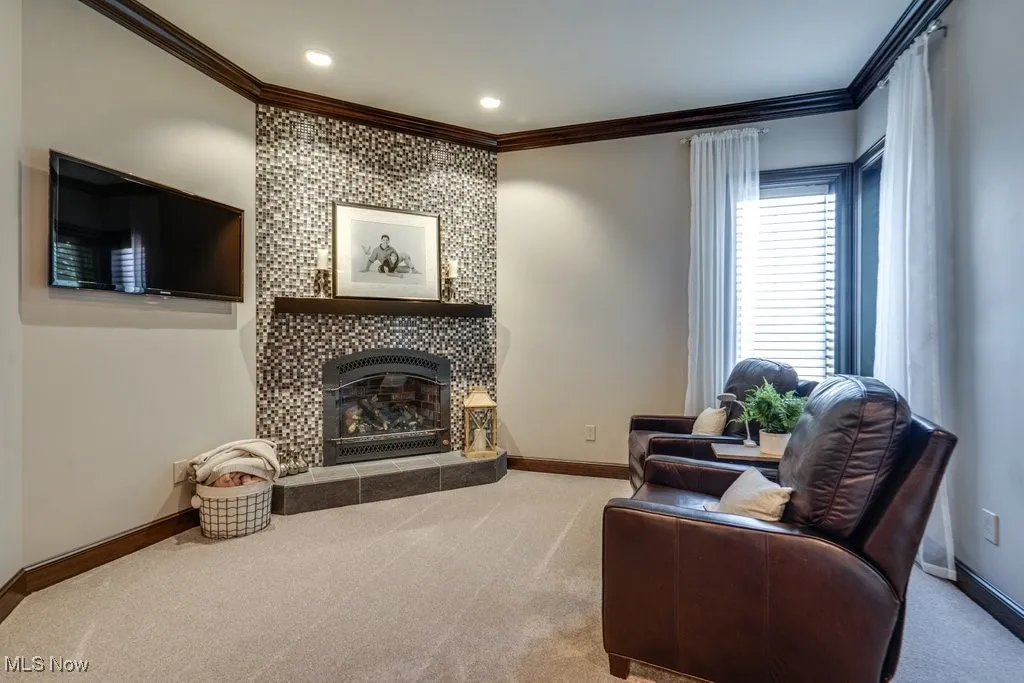 Sitting room with crown molding, carpet flooring, and a fireplace