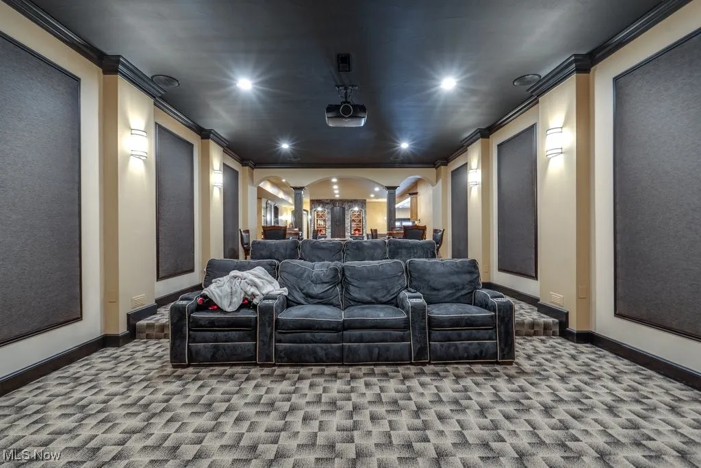 Cinema with crown molding, carpet flooring, arched walkways, and recessed lighting