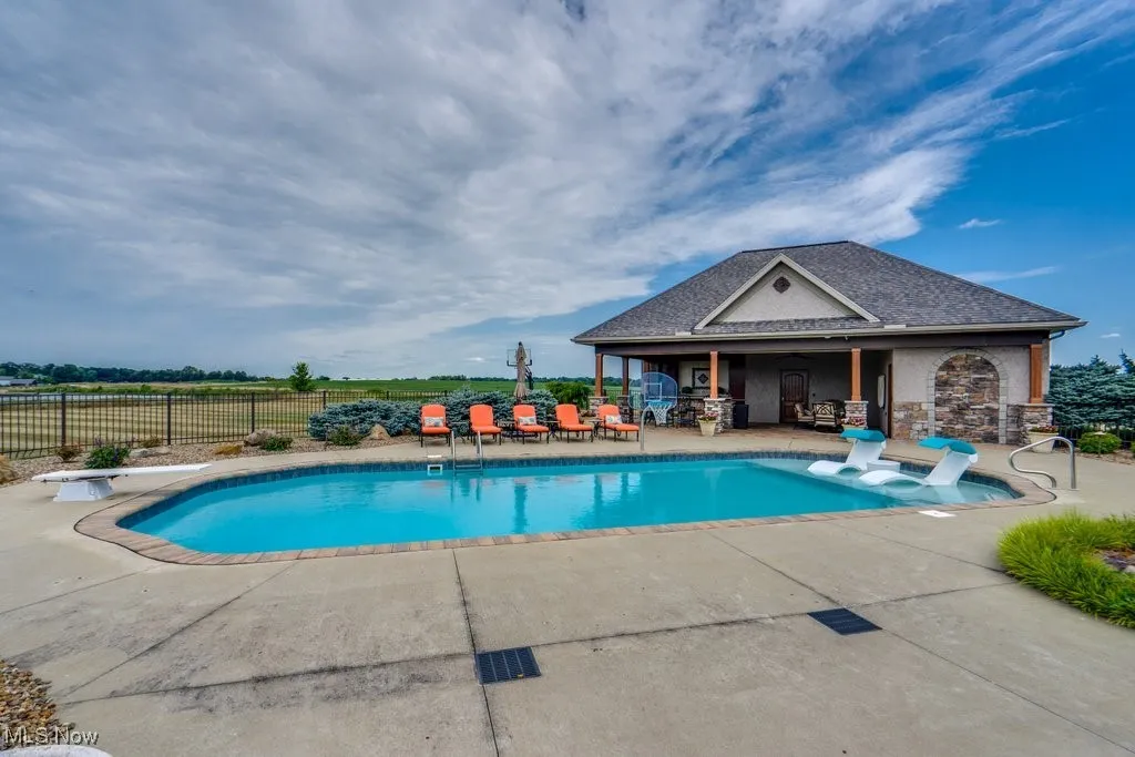 View of swimming pool with a patio area and a diving board