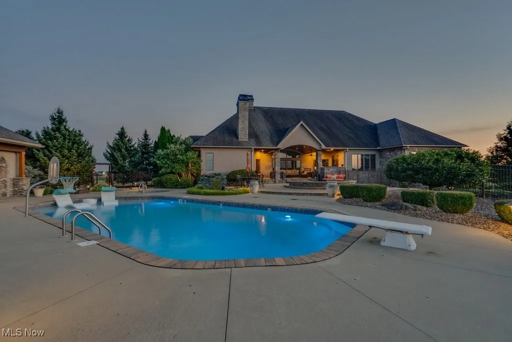 View of swimming pool with a patio area and a diving board