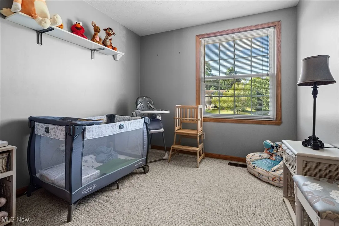 Bedroom featuring light colored carpet and a textured ceiling