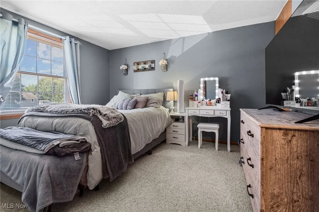 Bedroom featuring light carpet and a textured ceiling