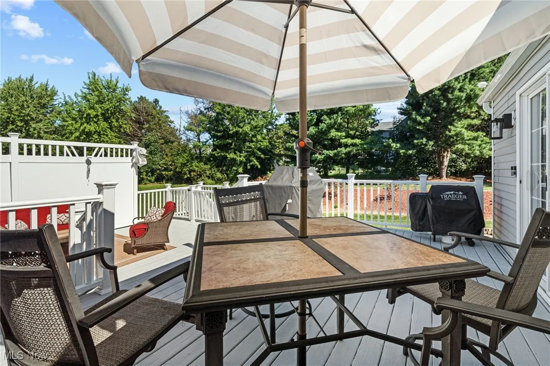 Wooden terrace with outdoor dining space and area for grilling