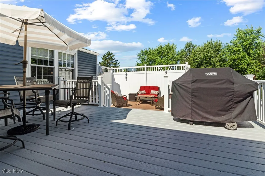 Wooden terrace featuring grilling area and outdoor dining space