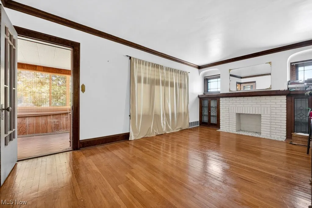 Second Floor living room with hard wood-style flooring, crown molding, and a fireplace