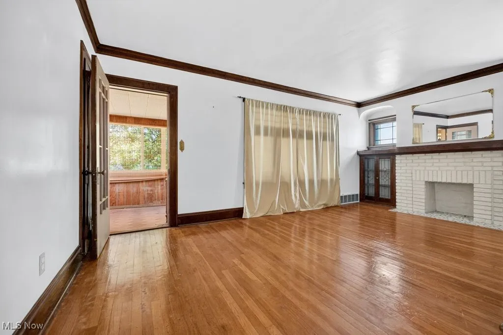 Second Floor living room with hard wood-style flooring, crown molding, and a fireplace