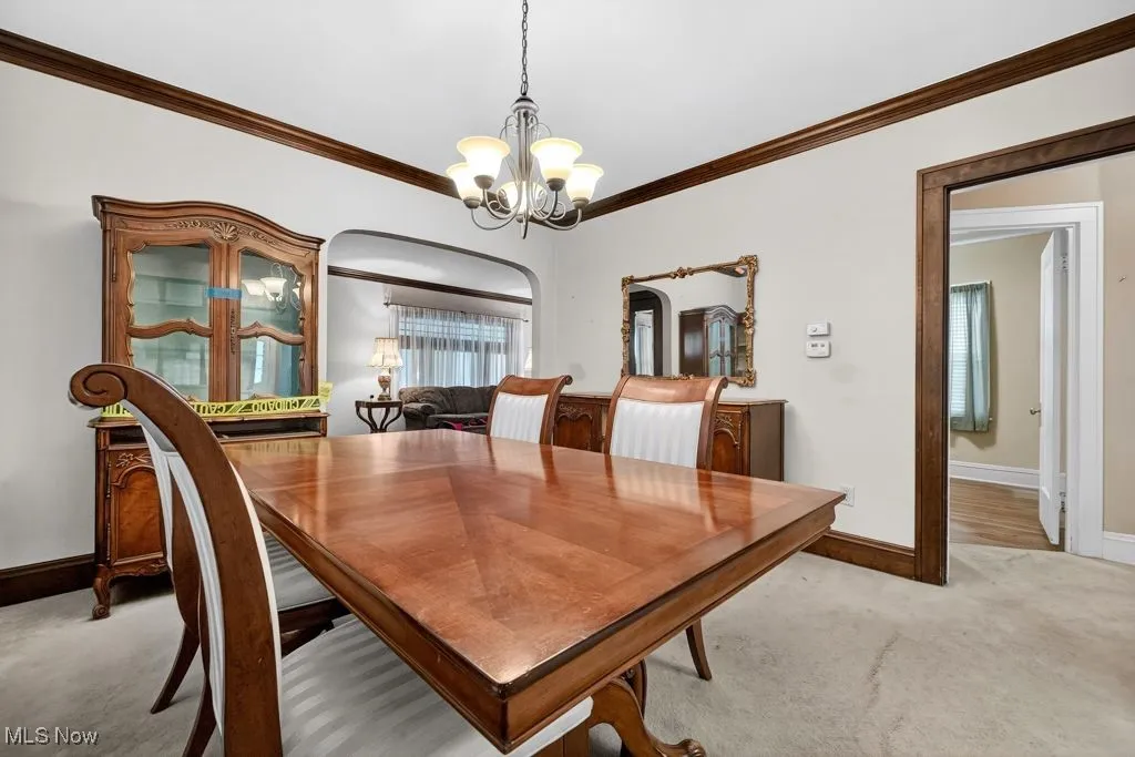 First Floor Carpeted dining area with  crown molding and a chandelier