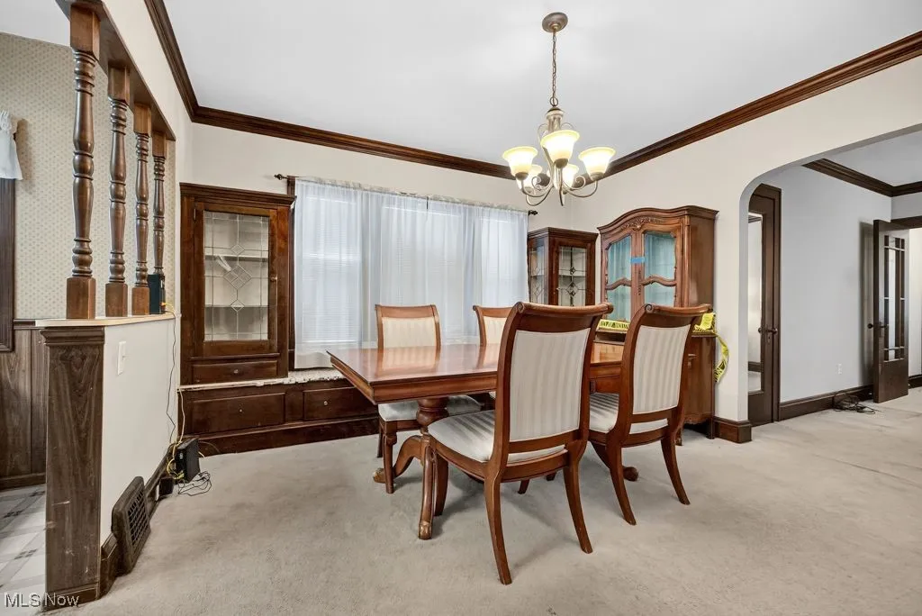 First Floor Dining area with crown  molding, light carpet, leaded glass cabinets with window seat.