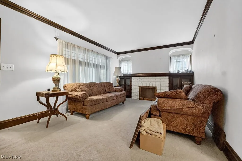 First Floor  Living room with healthy amount of natural light, a fireplace, carpet floors, and crown molding