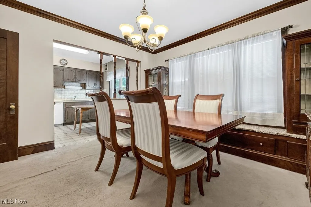 First Floor Dining area with crown  molding, light carpet, leaded glass cabinets with window seat.