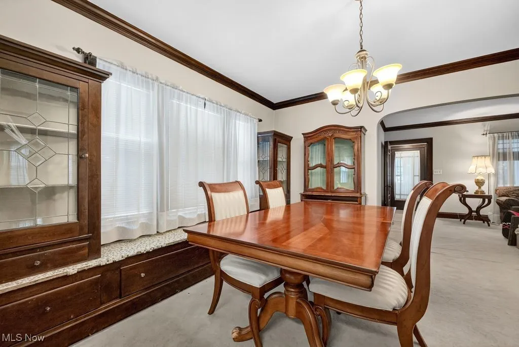 First Floor Dining area with crown  molding, light carpet, leaded glass cabinets with window seat.