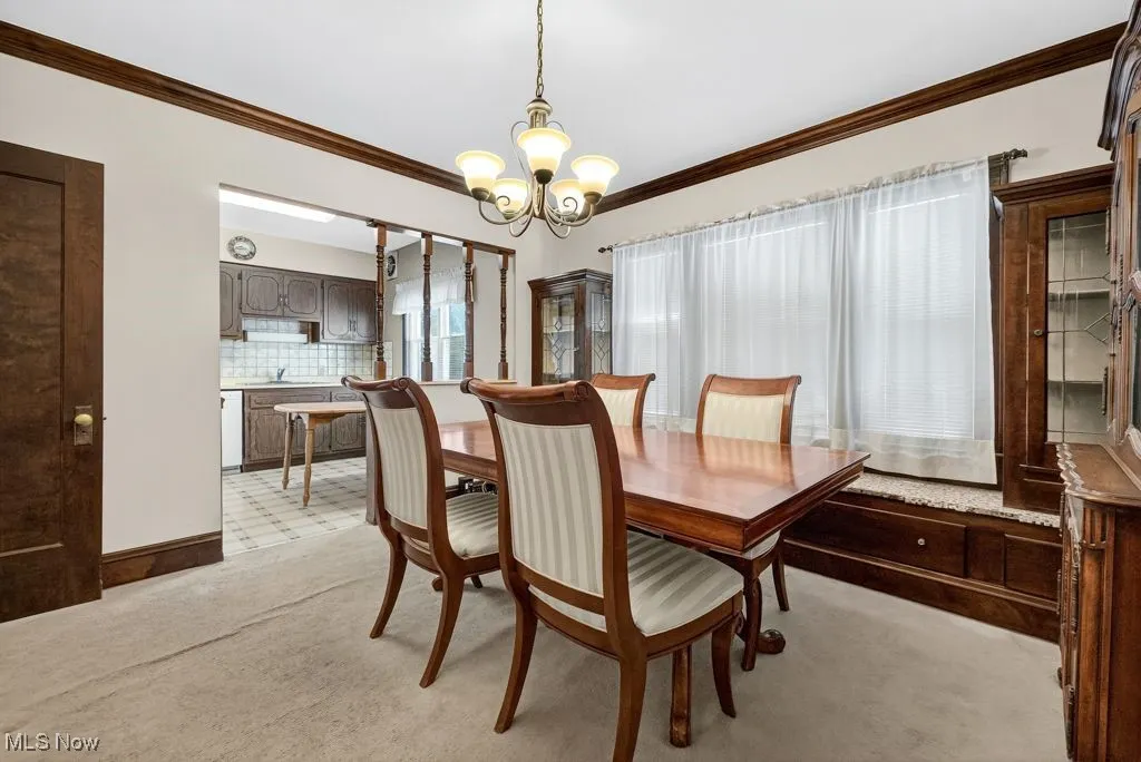 First Floor Dining area with crown  molding, light carpet, leaded glass cabinets with window seat.