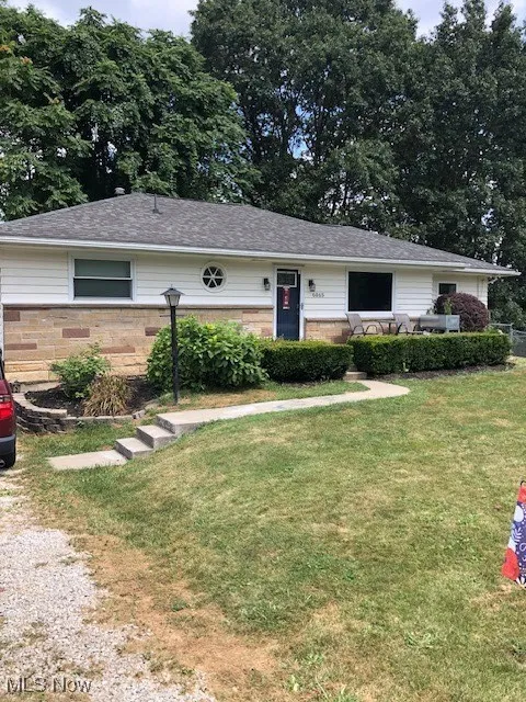 Ranch-style home with a front yard and roof with shingles