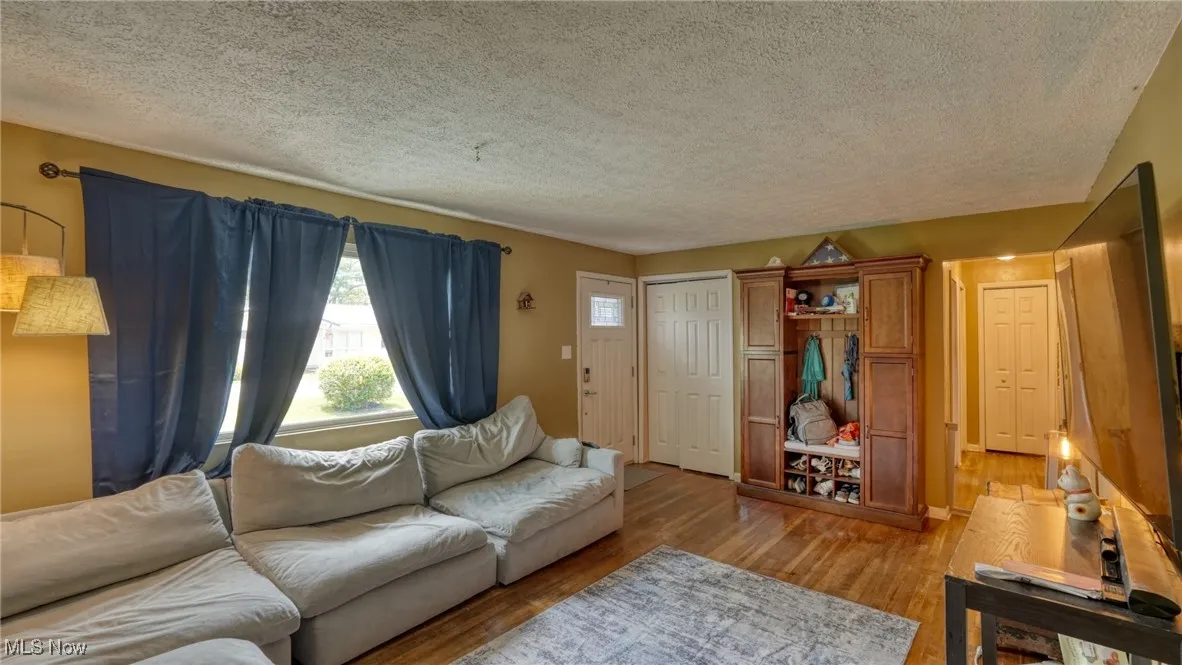 Living area featuring wood finished floors and a textured ceiling