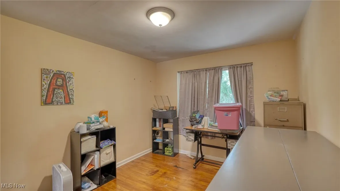 Home office with light wood-style flooring and baseboards