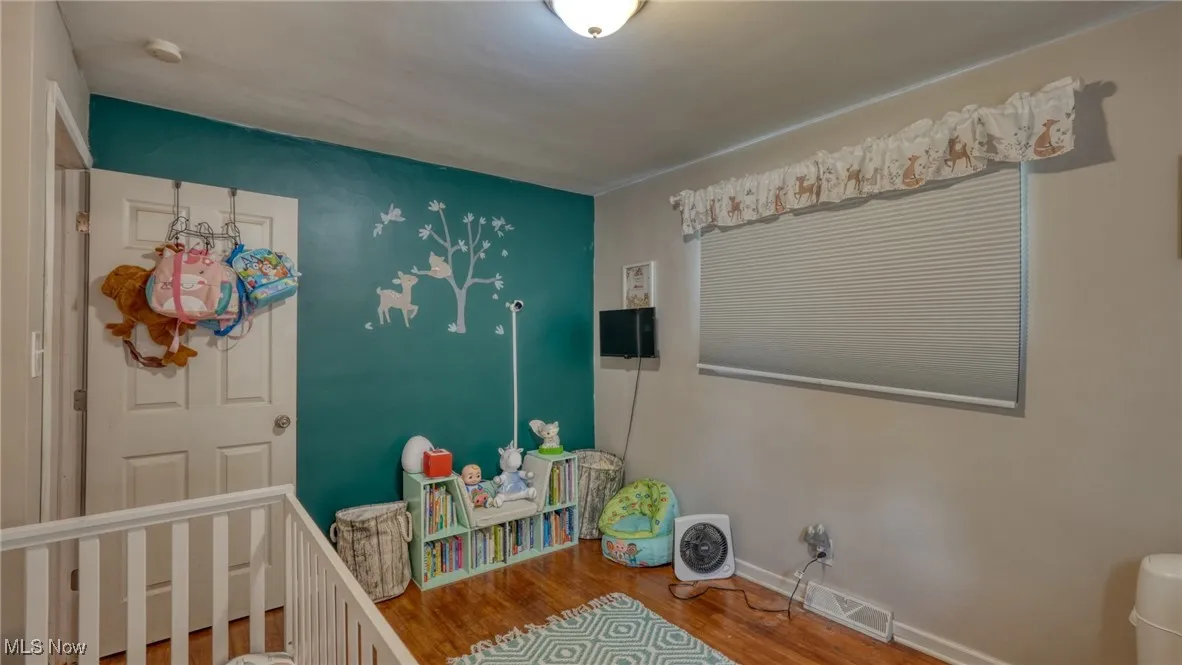Bedroom featuring wood finished floors and baseboards