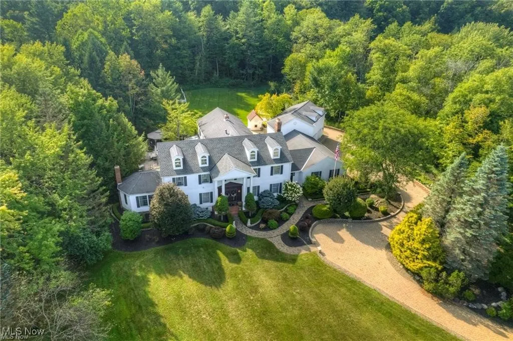 Aerial view of property and surrounding area featuring a heavily wooded area