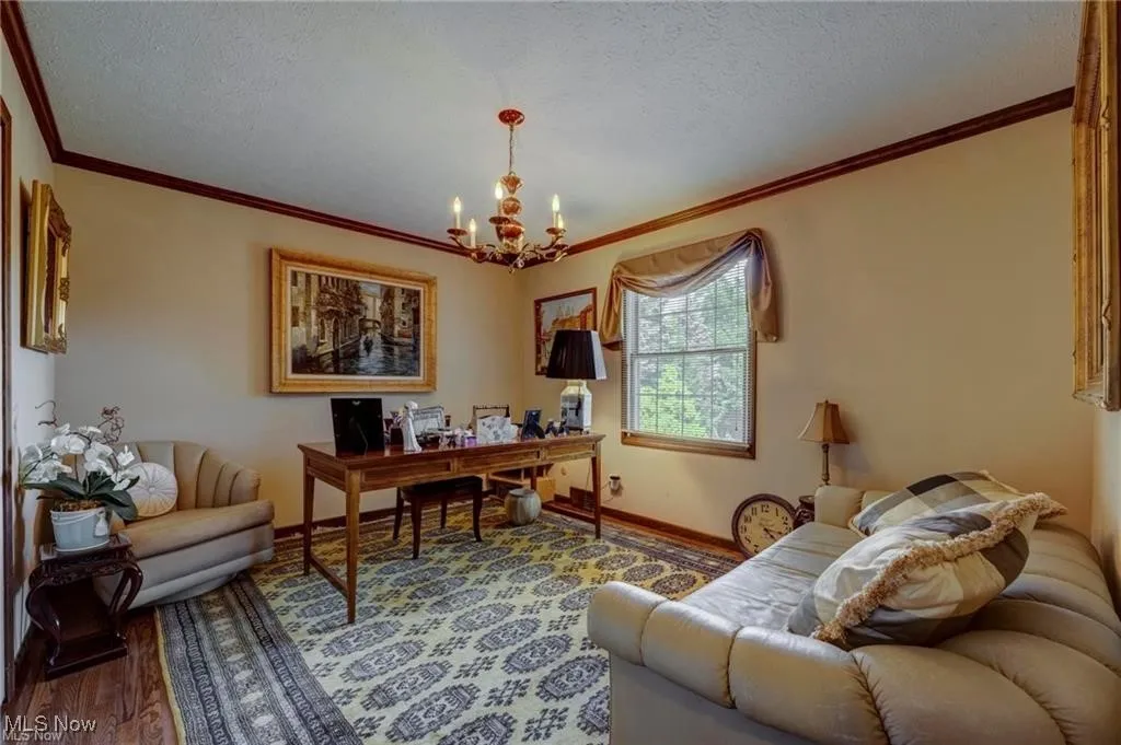 Office space featuring ornamental molding, wood finished floors, a textured ceiling, and a chandelier
