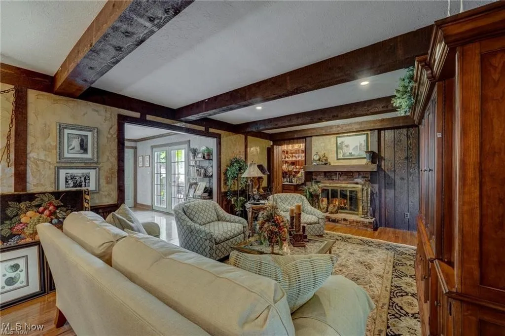  With wood finished floors, a fireplace, beam ceiling, and a textured ceiling