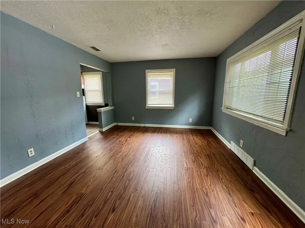 Spare room featuring a textured ceiling and wood finished floors