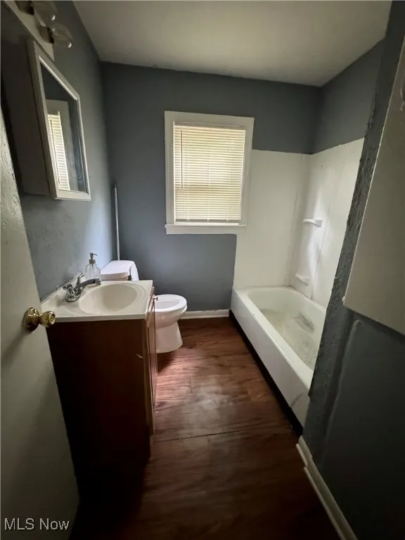 Bathroom with vanity, a tub to relax in, wood finished floors, and a shower