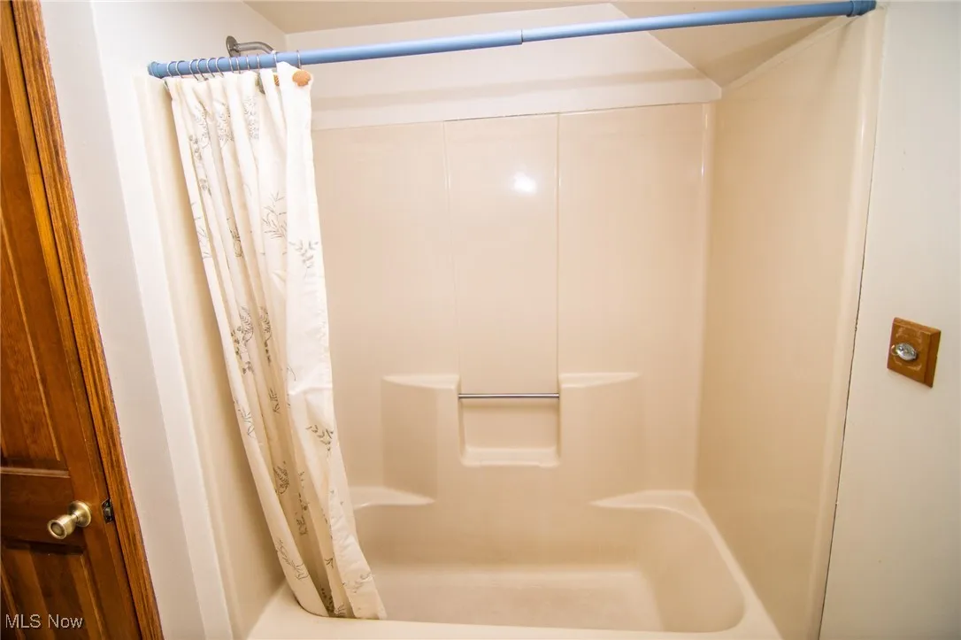 Bathroom featuring shower / bathtub combination with curtain