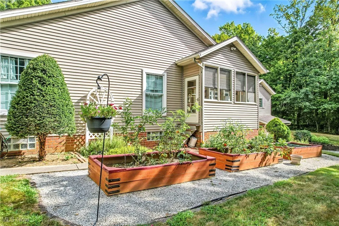 Side of home with raised beds for flowers or gardening