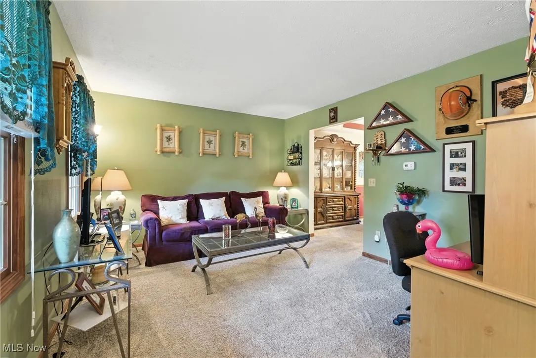 Carpeted living area with an office area and baseboards