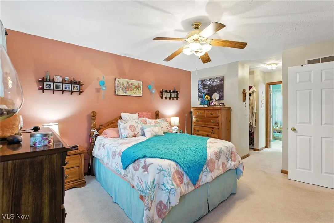 Bedroom with light carpet and ceiling fan