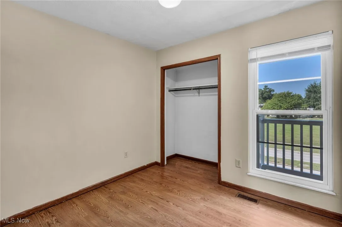 Unfurnished bedroom with light wood-style floors and a closet